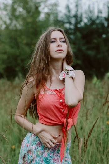 woman holding her neck on grass field
