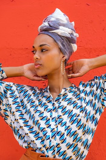 Woman Holding Her Neck Standing Near Wall
