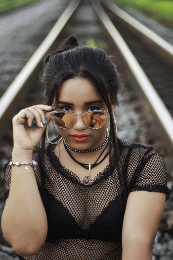 Woman Holding Her Sunglasses on Railway