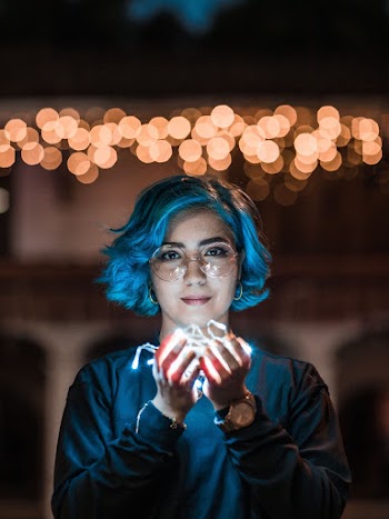 Woman Holding Illuminated String Lights
