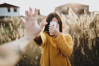 woman holding iPhone and touching other person's jhand