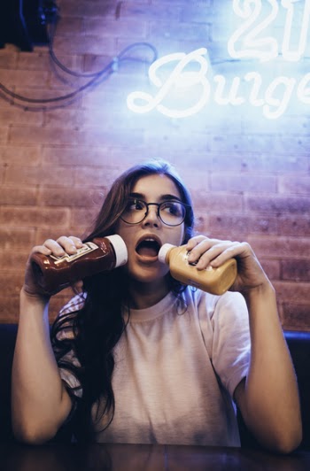 Woman Holding Ketchup And Mustard Bottles