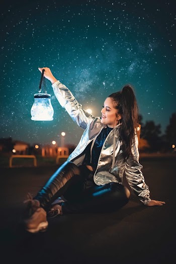 Woman holding lantern during nighttime