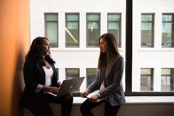 Woman Holding Laptop Computer Near Window
