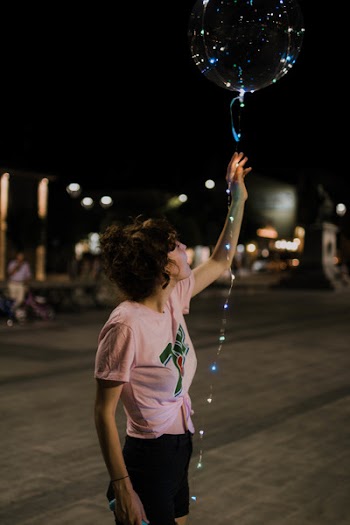 Woman Holding Lighted Balloon