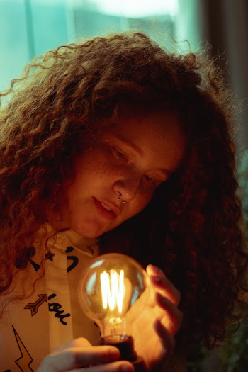 Woman Holding Lighted Led Bulb