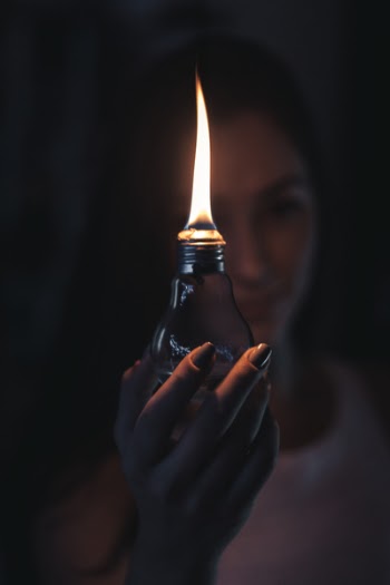 Woman Holding Lighted Oil Lamp