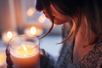 Woman Holding Lighted Votive Candle