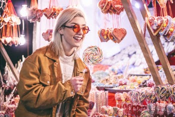 Woman Holding Lollipop While Smiling at Night-time