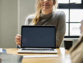Woman Holding Macbook Pro on Brown Surface