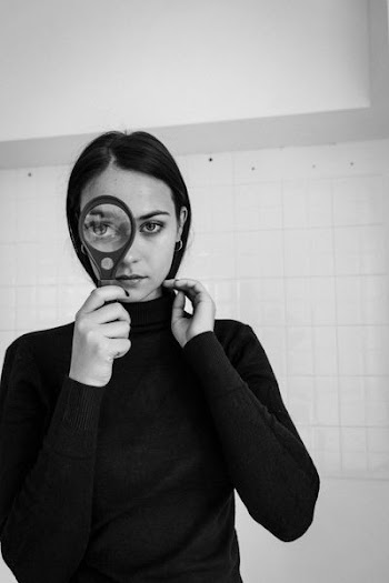 woman holding magnifying glass