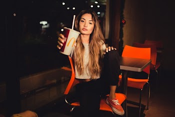 Woman Holding Mcdonalds Cup While Sitting on Chair