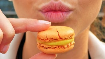 Woman Holding Orange Macaroon
