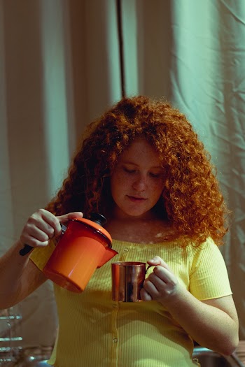 Woman Holding Orange Pitcher