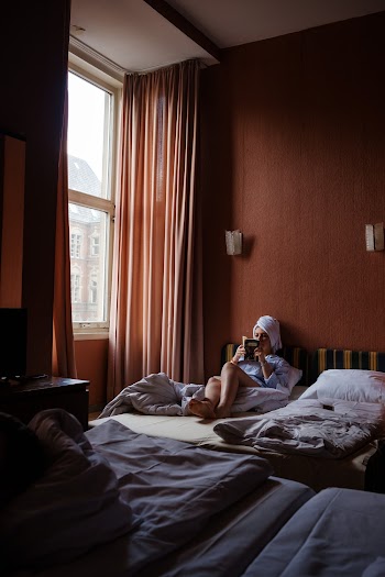 Woman Holding Phone in Bed