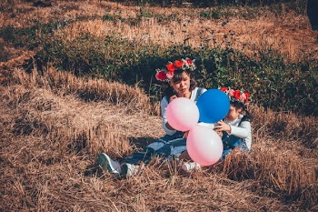 Woman Holding Pink and Blue Balloons
