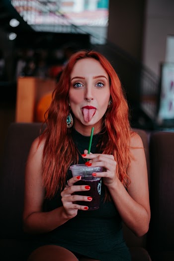 Woman Holding Plastic Cup With Tongue Out