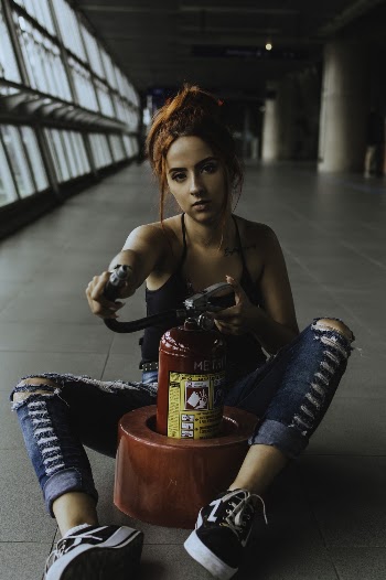 Woman Holding Red and Black Fire Extinguisher