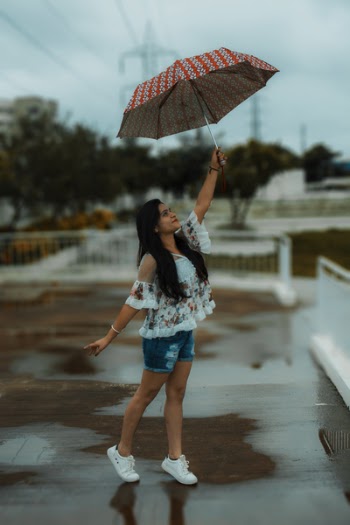 Woman Holding Red and Gray Umbrella While Raising It
