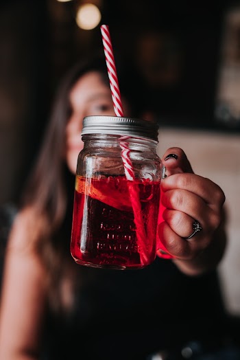 Woman Holding Red Glass Mason Jar