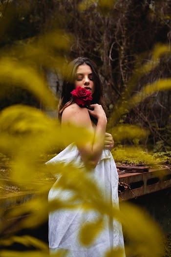 Woman Holding Red Rose While Covering White Cloth