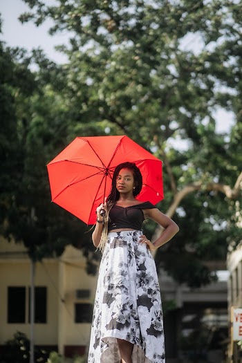 Woman Holding Red Umbrella While Wearing Black Crop Top and White and Black Floral Dress