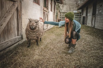 Woman Holding Sheep Beside Wall