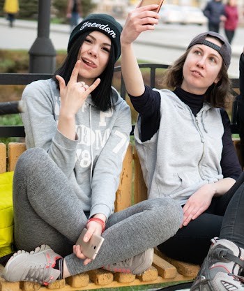 Woman Holding Smartphone While Taking Selfie Beside Woman Wearing Black Knit Cap