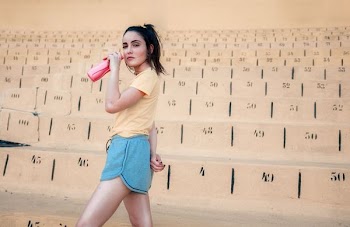 woman holding sports bottle standing beside blocks with numbers