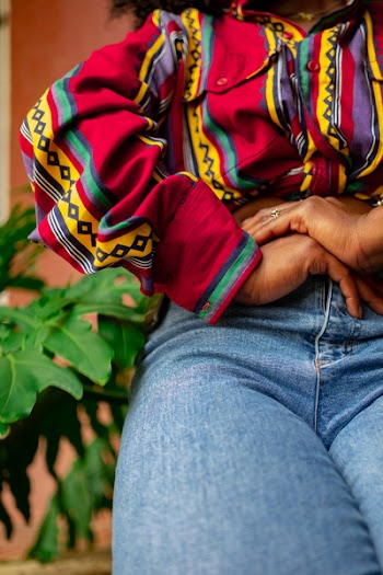 Woman Holding Stomach Near Green Leaf Plant