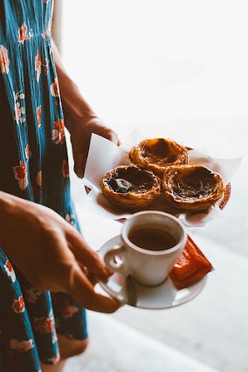 Woman Holding Teacup and Plate of Food