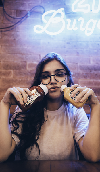 Woman Holding Two Ketchup Bottles