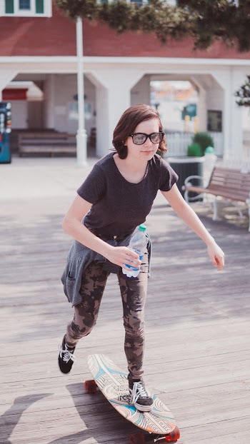 Woman Holding Water Bottle Skateboarding