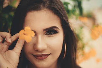 Woman Holding Yellow Petaled Flowers Covering Her Right Eye