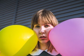 Woman Holding Yellow Pink and Yellow Balloons