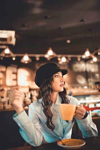 Woman Holds Hot Beverage Cup at the Restaurant