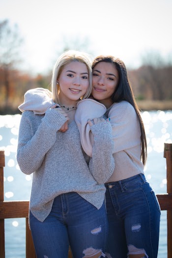 Woman Hugging Another Woman While Standing Near Body Of Water