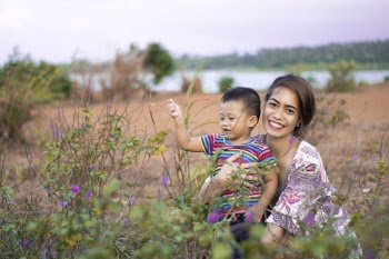 Woman Hugging Boy on Field