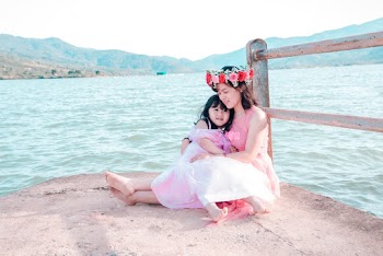 Woman Hugging Girl Sitting on Dock