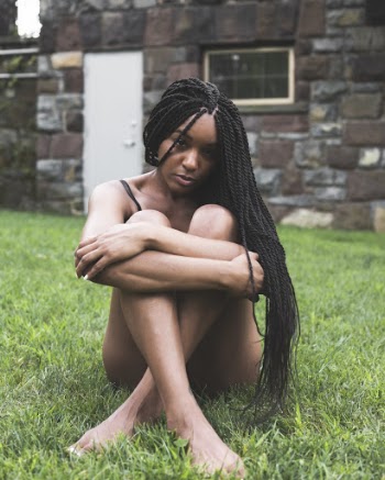 Woman Hugging Knees Sitting on Green Grass
