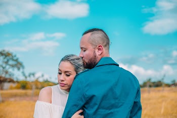 Woman Hugging Man Standing on Open Field Under White and Blue Cloudy Skies