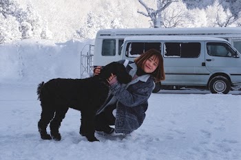 Woman Hugging Short-coated Black Dog