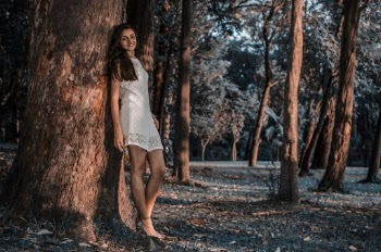 Woman iI White Lace Dress Standing Beside Tree