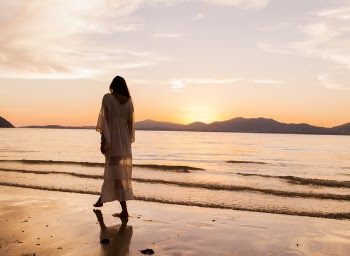 Woman iIn White Dress Walking On Beach