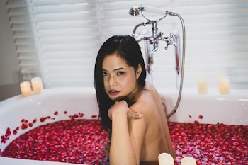Woman In A Bathtub Touching Her Shoulder