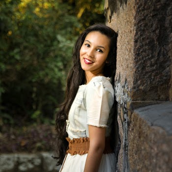 Woman In A Dress Leaning Against Concrete Wall