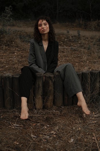 Woman in a Suit and Face Paint Posing in the Forest