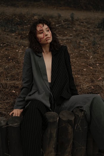 Woman in a Suit and Face Paint Posing in the Forest