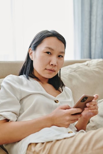 Woman in a White Shirt Using Her Cell Phone · Free Stock Photo