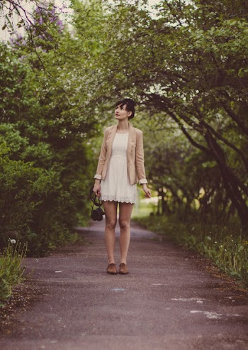 Woman in Beige Blazer Standing on Pathway Surrounded by Green Trees during Daytime